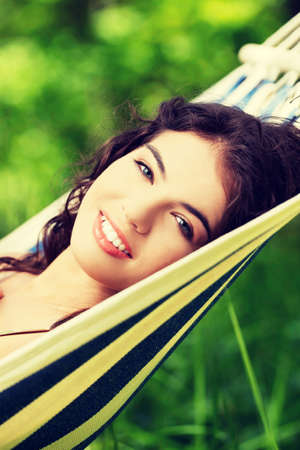 Young woman lying in a hammock in gardenの写真素材