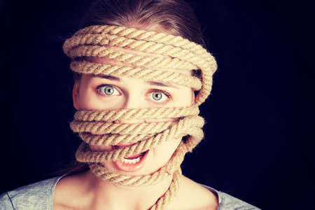Tied up woman screaming. Violence concept.の写真素材