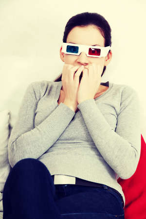 Sceared woman in 3d glasses is watching movie.の写真素材