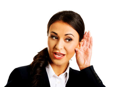 Young beautiful businesswoman overhears someone.の写真素材