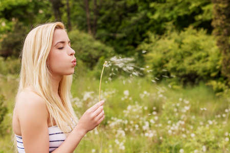 Young blonde woman posing with flowers . Outdoor shot.の写真素材