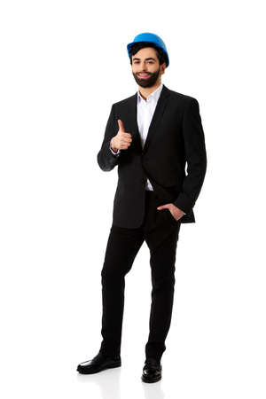 Smiling businessman with hard hat showing ok sign.の写真素材