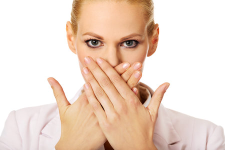 Young business woman covering her mouth with two hands.
