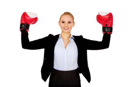 Business woman in boxing gloves standing in victory pose.の写真素材