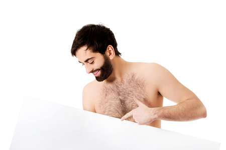 Young handsome shirtless man pointing on empty banner.の写真素材
