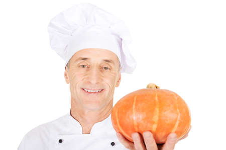 Male chef in uniform holding a pumpkinの写真素材