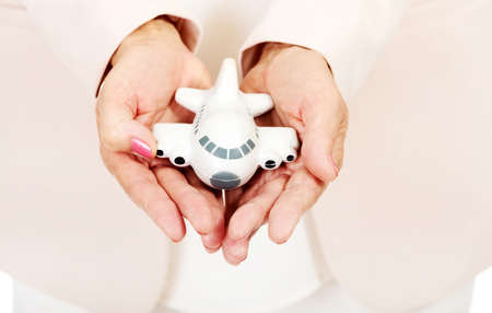 Elderly woman holding a toy plane on open plams.の写真素材