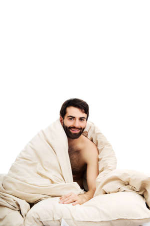 Young man waking up in bed.の写真素材
