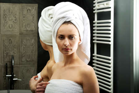 Beautiful woman wrapped in towel at bathroom.の写真素材