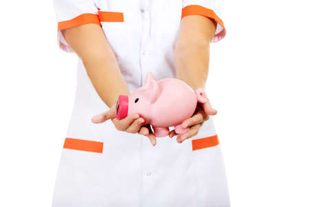 Smile elderly female doctor or nurse holding piggybank.の写真素材