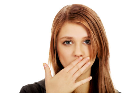 Teenage woman covering mouth with hand.