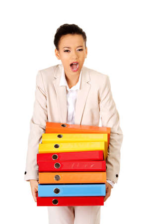 Shocked businesswoman holding heavy bidners.の写真素材