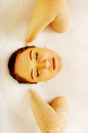 Young woman washing hair in bath.の写真素材