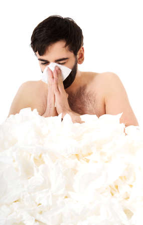 Sick man with a lot of tissues sneezing into handkerchief.の写真素材