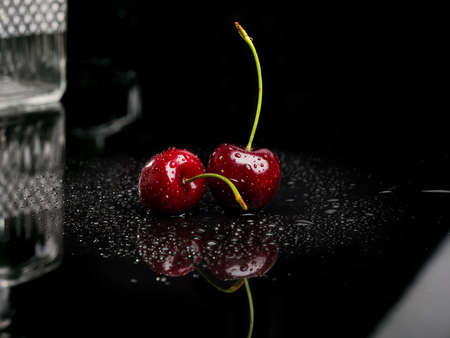 Two juicy fresh wet cherries.の写真素材
