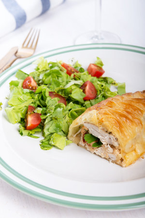 Chicken breast in french pastry with fresh salad.の写真素材
