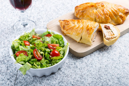 Chicken breast in french pastry with fresh salad.の写真素材