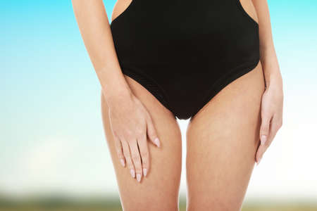 Beautiful slim woman's body in black swimsuit.の写真素材