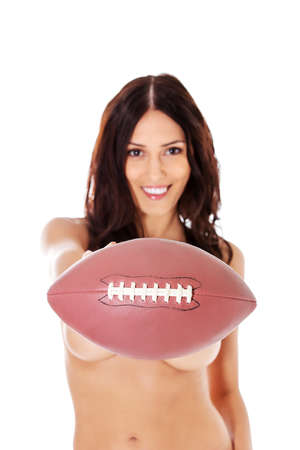Beautiful woman nude holding an american football isolated over white background.の写真素材