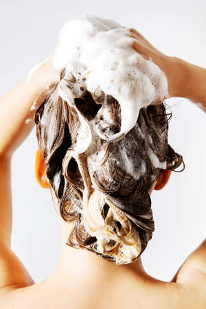 Blond woman taking a shower and shampooing her hair. Isolated on white.の写真素材