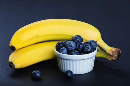 Two bananas and heap of huckleberries.の写真素材