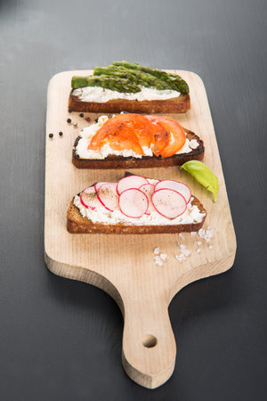 Three different sandwich on wooden board.