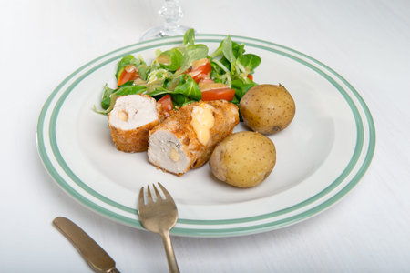 Kiev cutlet with jacket potatoes and salad.の写真素材