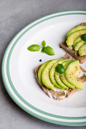 Sandwich with avocado slices and basil.の写真素材