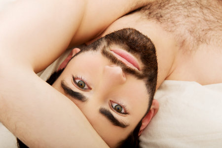 Young handsome man lying in bed.の写真素材