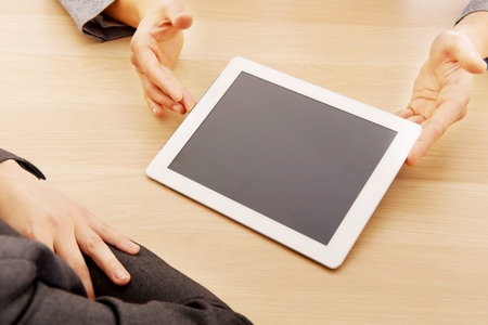 Business meeting-man showing something on tablet.