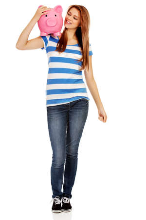 Happy teenage woman holding piggybank.の写真素材
