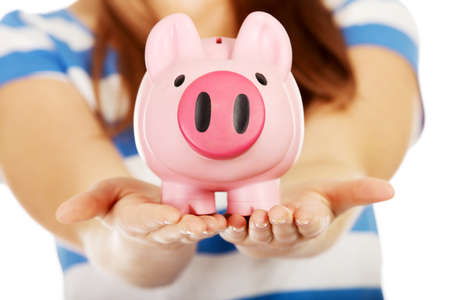 Teenage woman holding pink piggybank.の写真素材