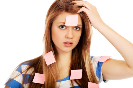 Teenage woman covered with post it notes.