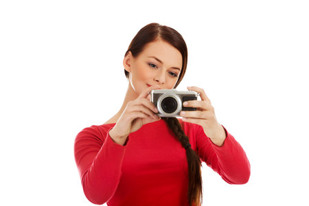 Pretty woman taking a photo using classic slr camera.