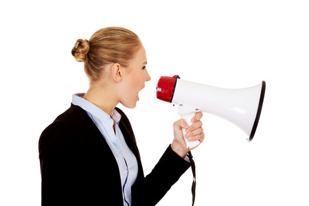 Young business woman screaming through megaphone.の写真素材
