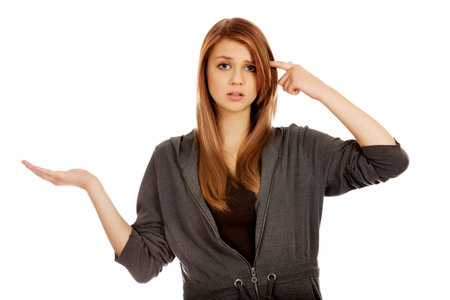 Teenage woman holding something on open palm and thinking about something.