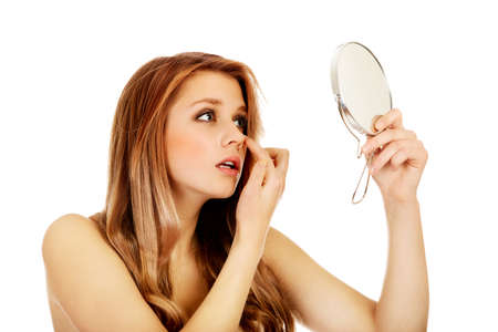 Young beautiful woman looking in a mirror.の写真素材