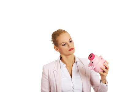 Young business woman kissing a piggybank.の写真素材