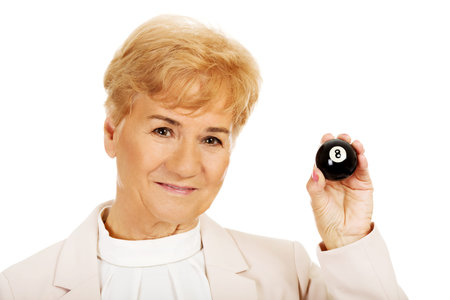Happy elderly business woman holding eight billard-ball.の写真素材