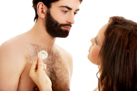 Beautiful woman giving a condom to her handsome man.の写真素材