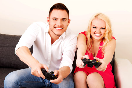 Happy young couple playing video games.