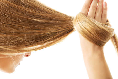 Long blond human hair close-up, isolated on white.の写真素材