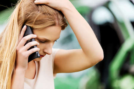 Female driver making phone call after traffic accident.の写真素材
