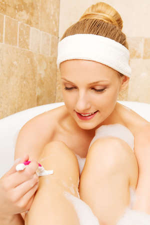 Yyoung caucasian woman shaving legs.の写真素材