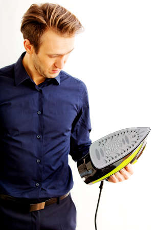 Young businessman ironing his jacket.の写真素材