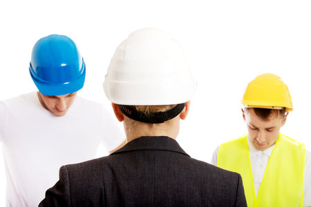 Female engineer talking with two builders.