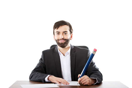 Happy businessman writing with big pencil in the office.の写真素材