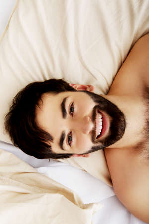Young handsome man lying in bed.の写真素材