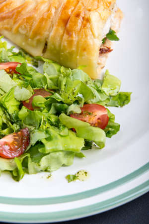 Chicken breast in french pastry with fresh saladの写真素材