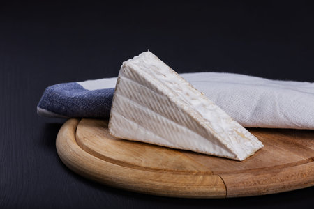 Aromatic brie cheese on cutting board